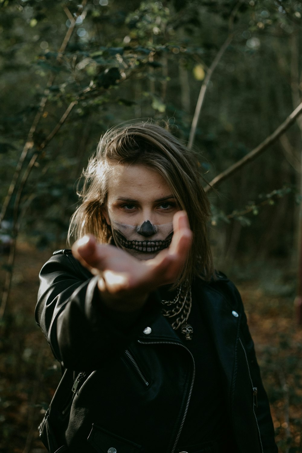 woman in black leather jacket holding her face