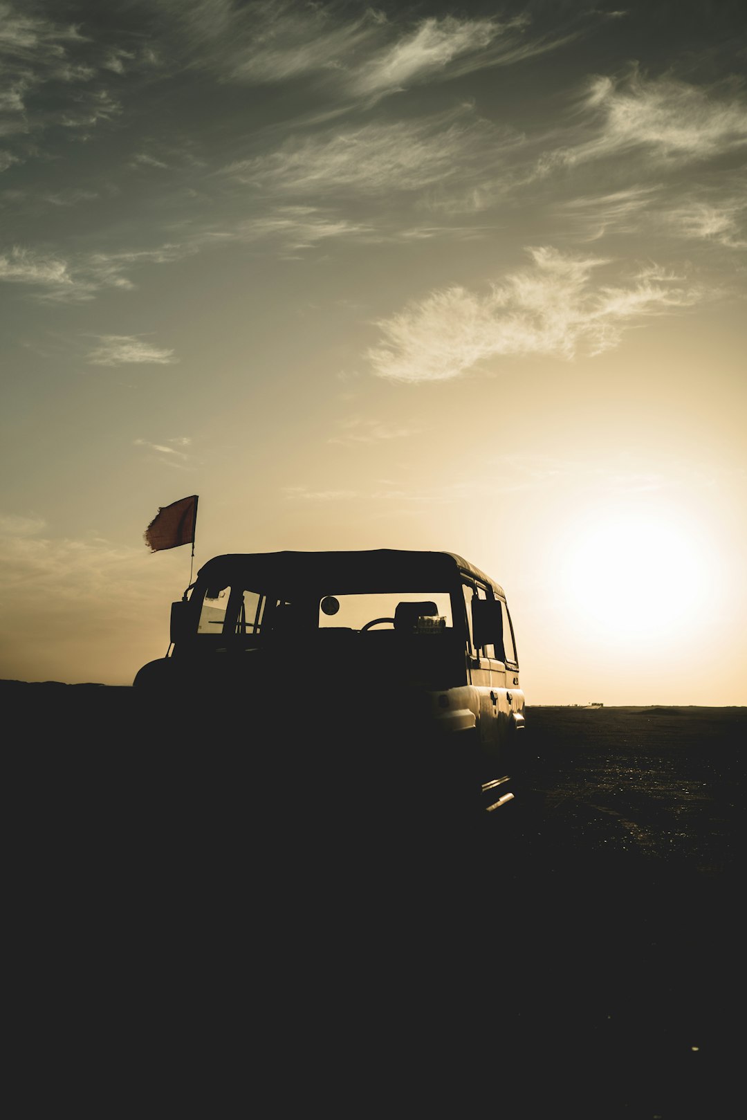 silhouette of car on field during sunset