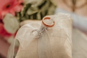 Close-up of vintage wedding rings resting on a cream-colored silk fabric with muted gold accents.