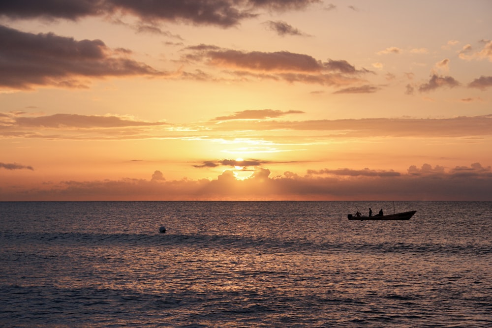 silhouette of people on boat during sunset