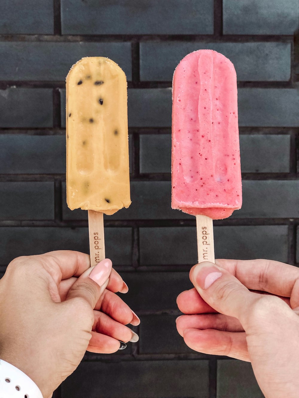 person holding yellow ice cream