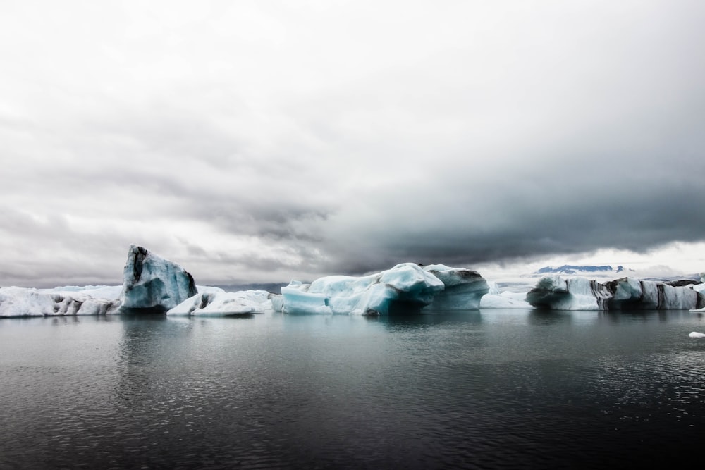 white ice on water under gray clouds