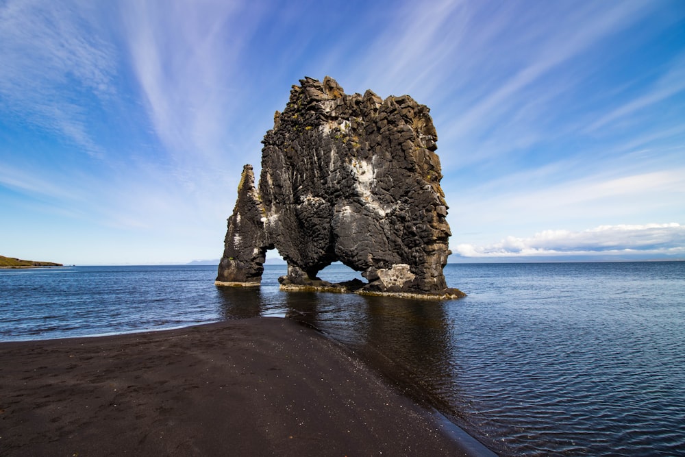 a large rock sticking out of the ocean