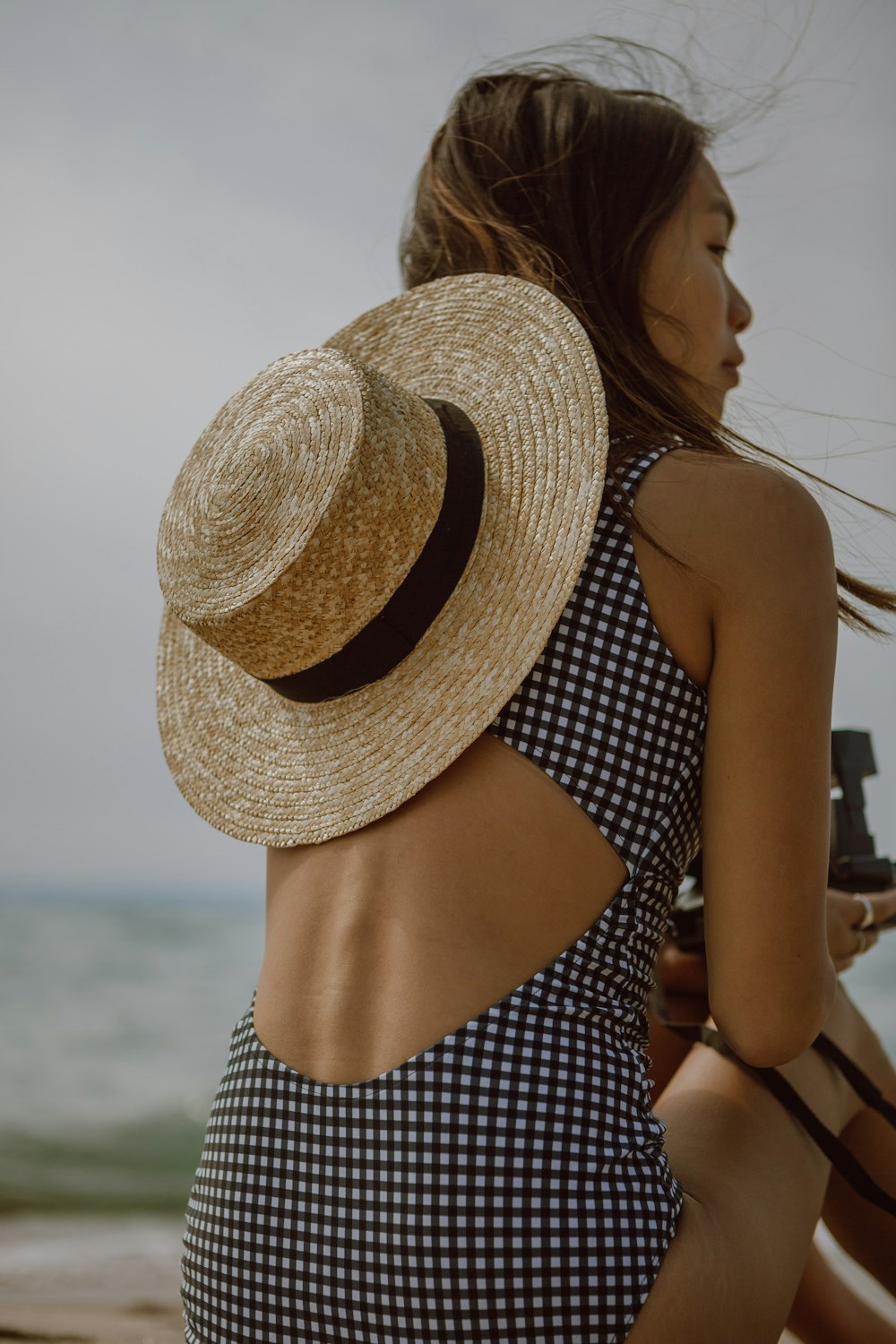 갈색 밀짚 모자를 쓰고 흑백 물방울 무늬 스파게티 스트랩 탑에 여자