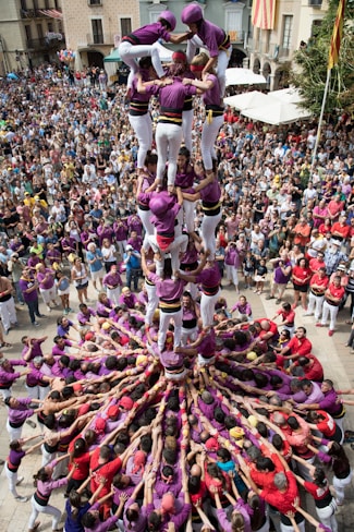 people in pink and purple dress dancing on street during daytime