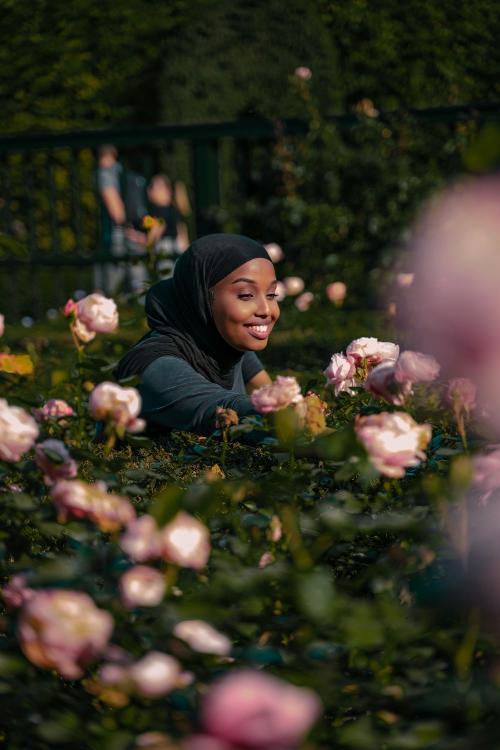 woman in black hijab holding white flowers