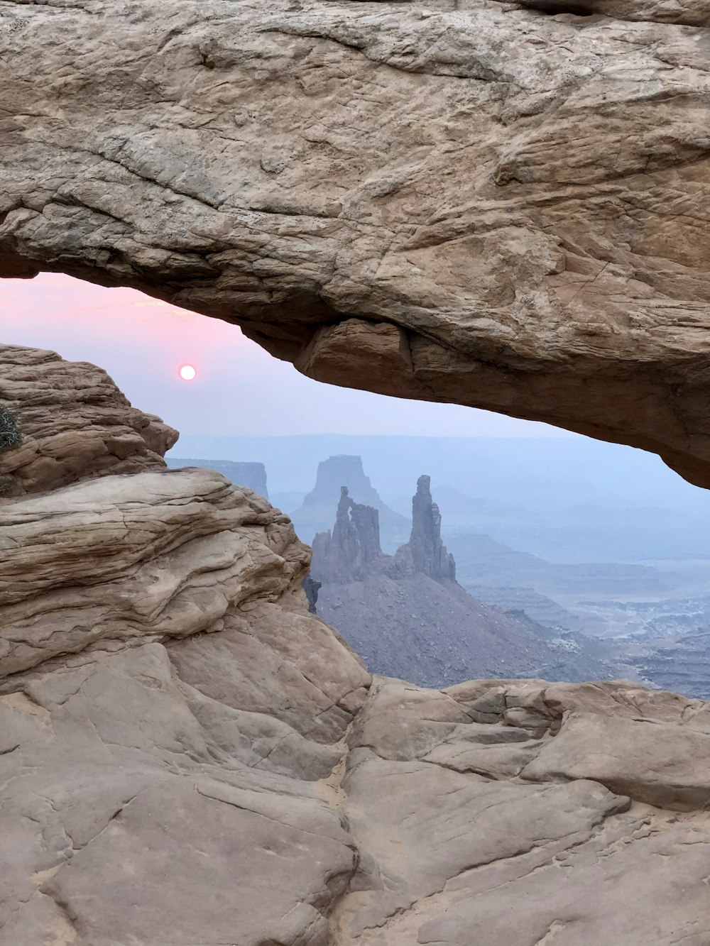 person in black jacket standing on rock formation during daytime