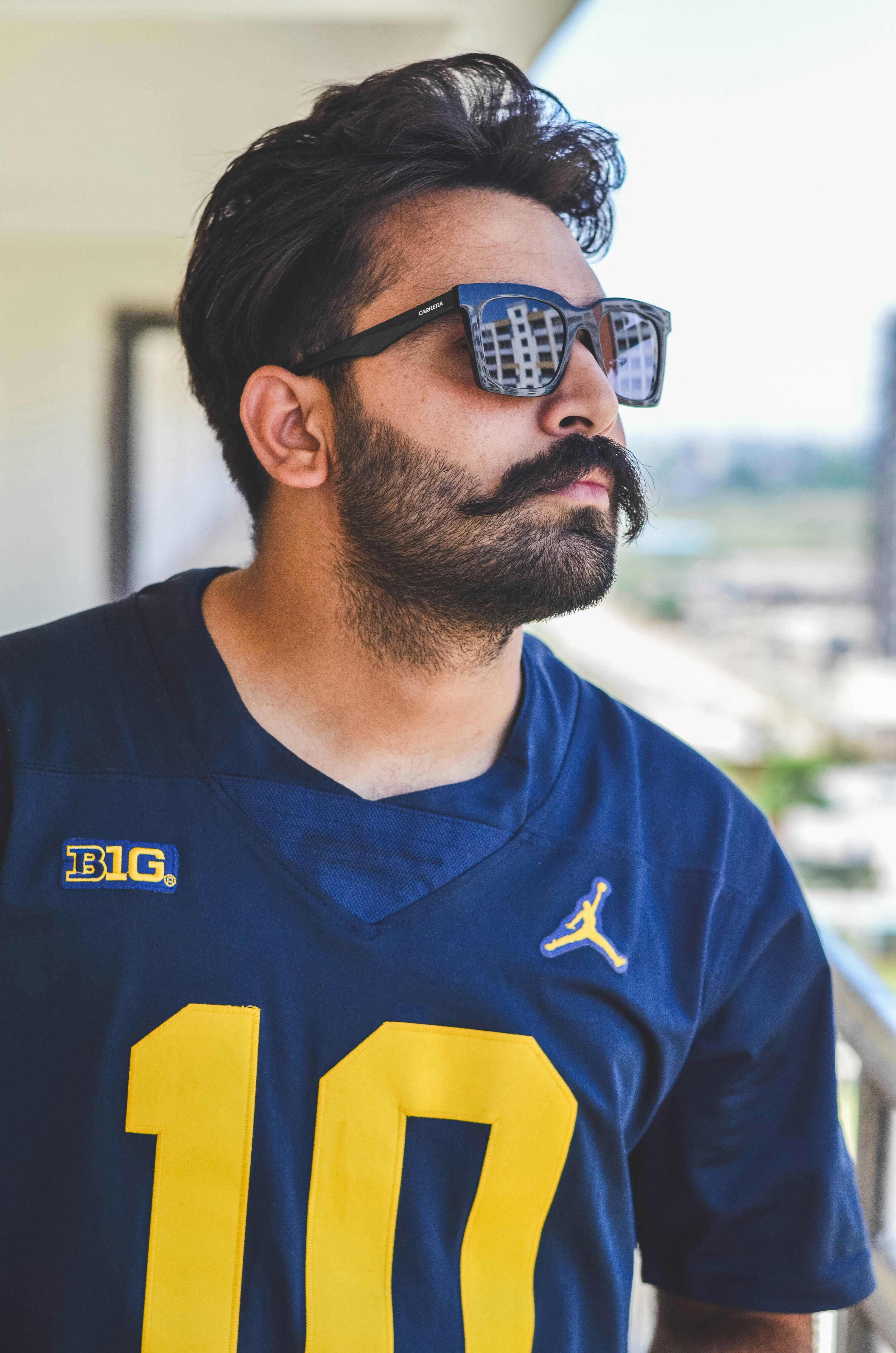 man in blue and yellow adidas v neck shirt wearing black sunglasses