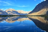 lake near mountain under blue sky during daytime