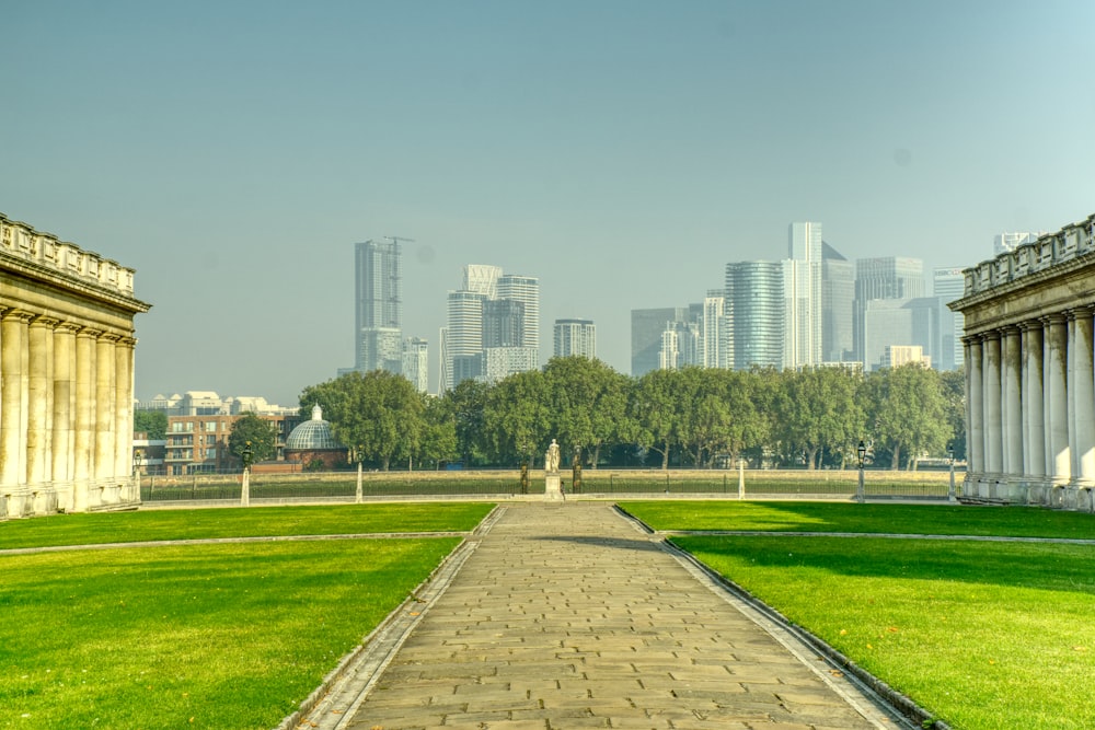 person walking on pathway near green grass field during daytime