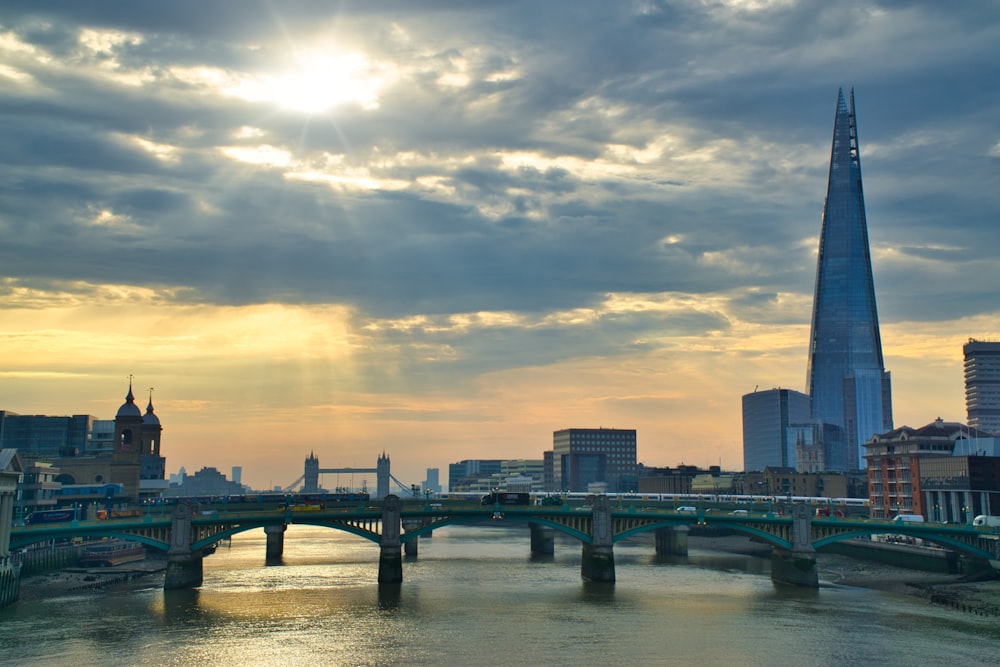 bridge over river under cloudy sky during daytime