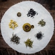 Assorted colorful herbal tea bags arranged with dried flowers and leaves