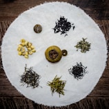 Herbal tea blend with fresh flowers and delicate petals arranged on a linen cloth.