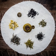 A vibrant display of TTC Luxury Teas arranged with fresh leaves and teacups.