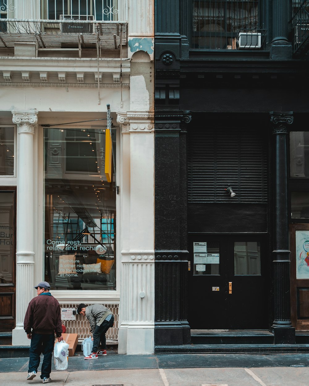 man in red jacket standing in front of store