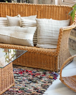 brown wicker framed glass top coffee table and couch