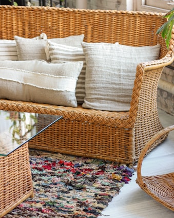 brown wicker framed glass top coffee table and couch