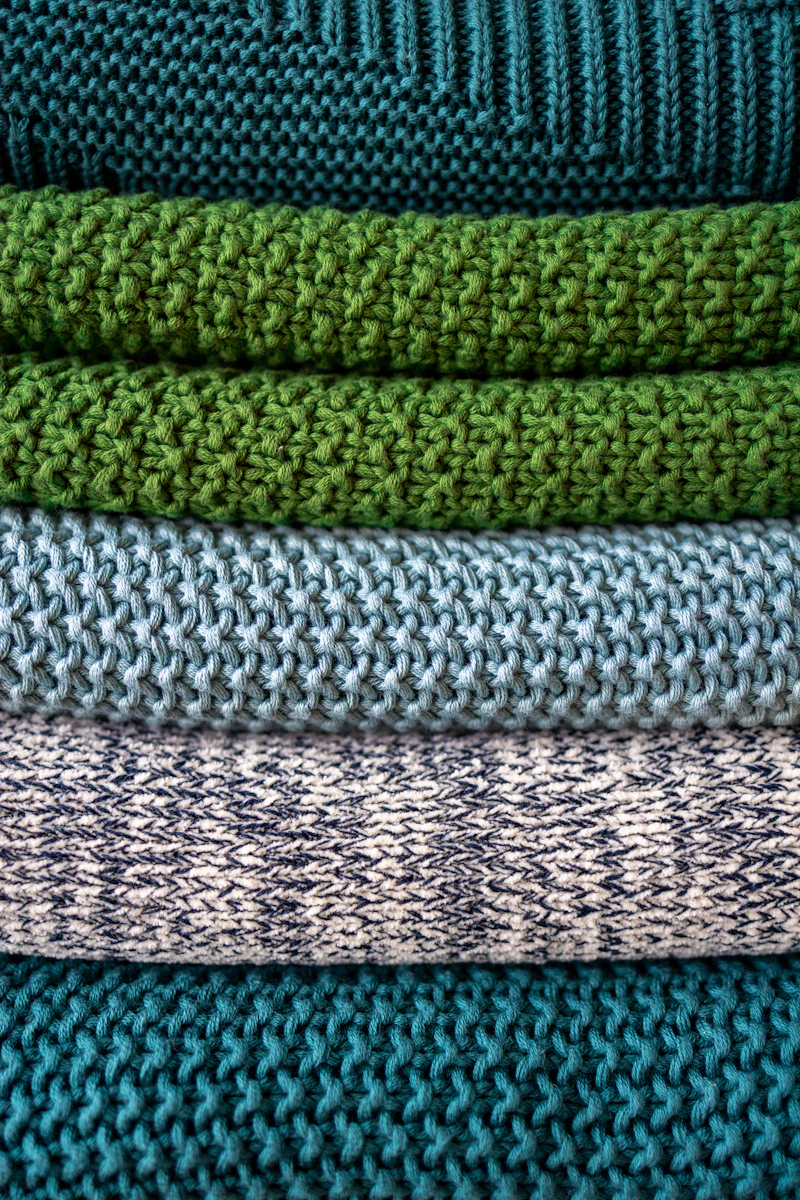 Hand-knit textiles folded on a shelf