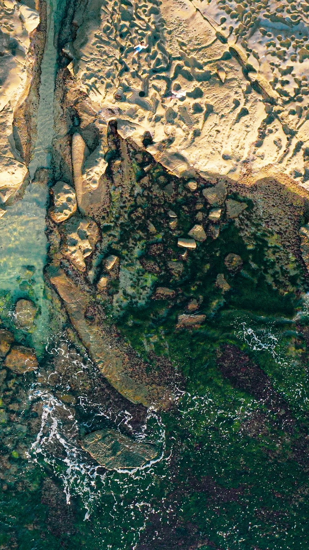 brown rock formation on body of water during daytime