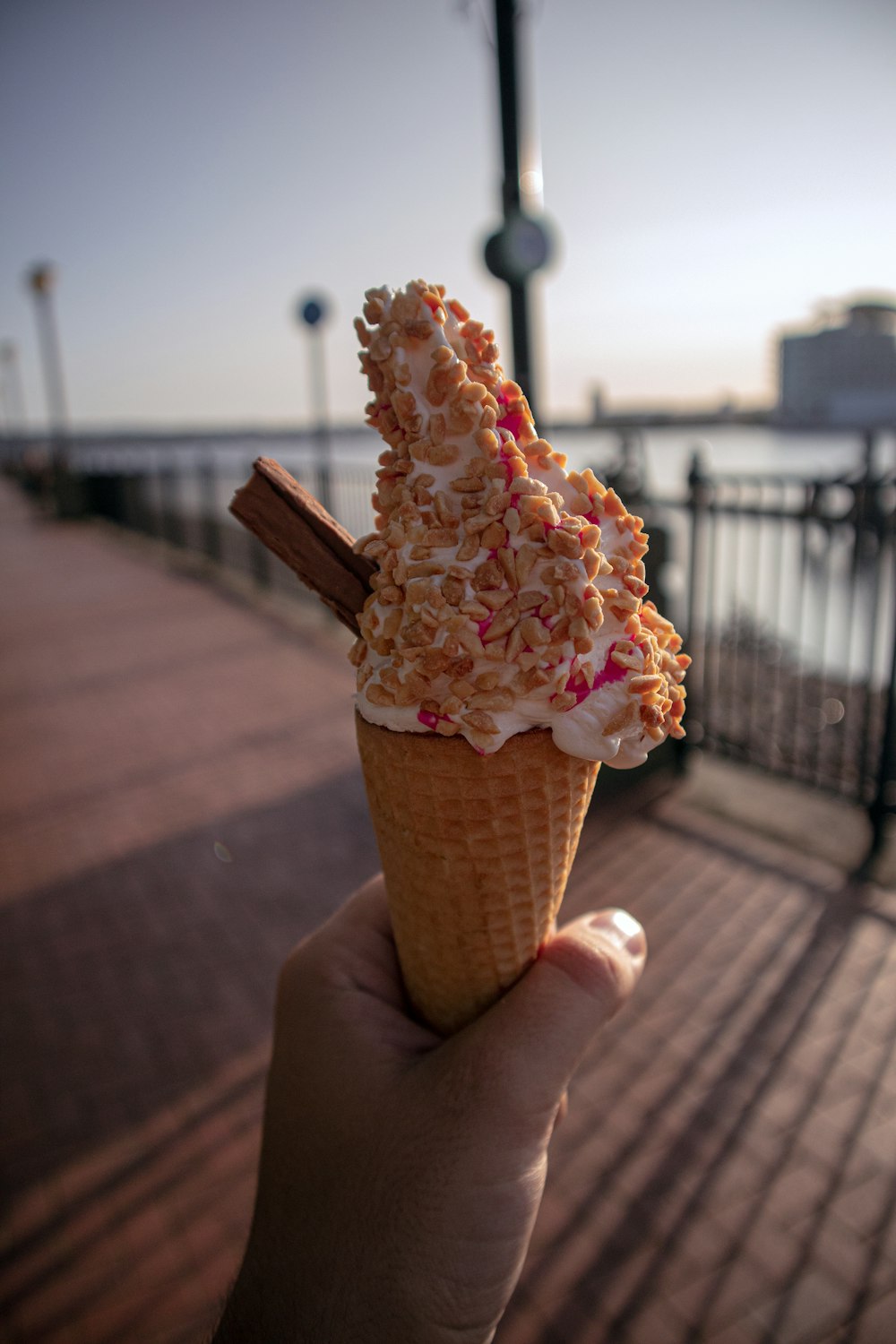 person holding ice cream cone with white ice cream