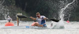 Action shot of a canoe polo player in vibrant gear making a powerful stroke.