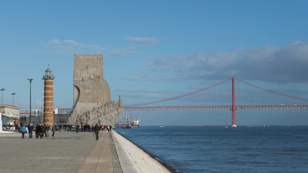 people walking on sidewalk near bridge during daytime