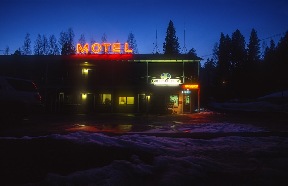 a motel lit up at night in the snow