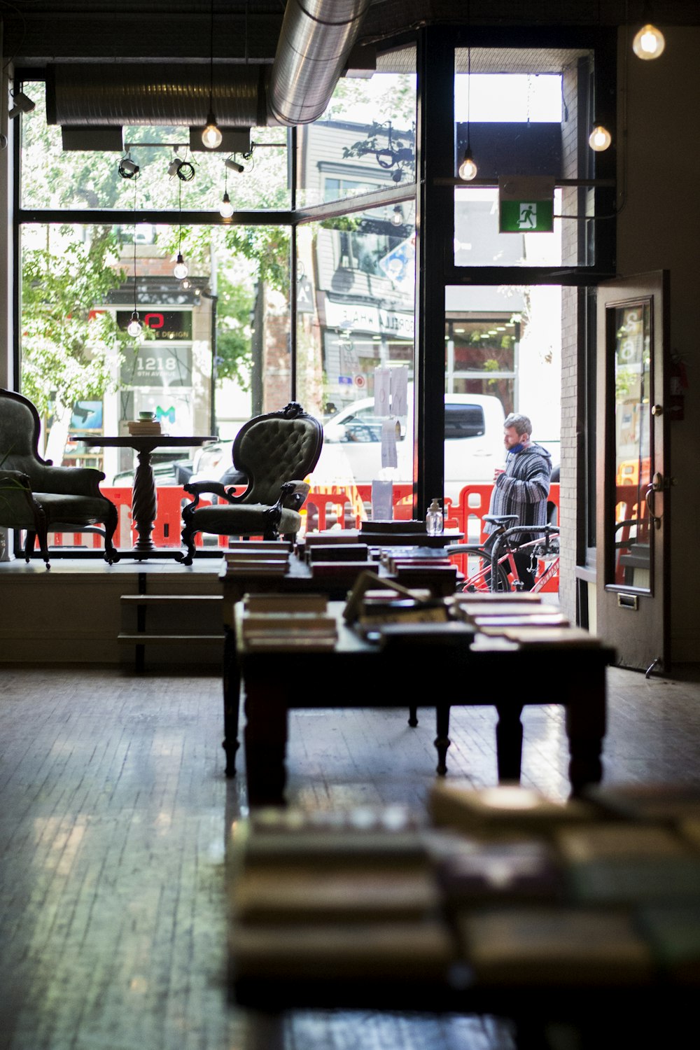 man in red shirt standing near glass window