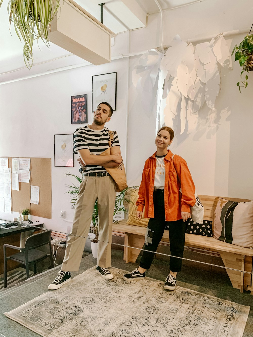 man in orange robe standing beside woman in black and white striped long sleeve shirt