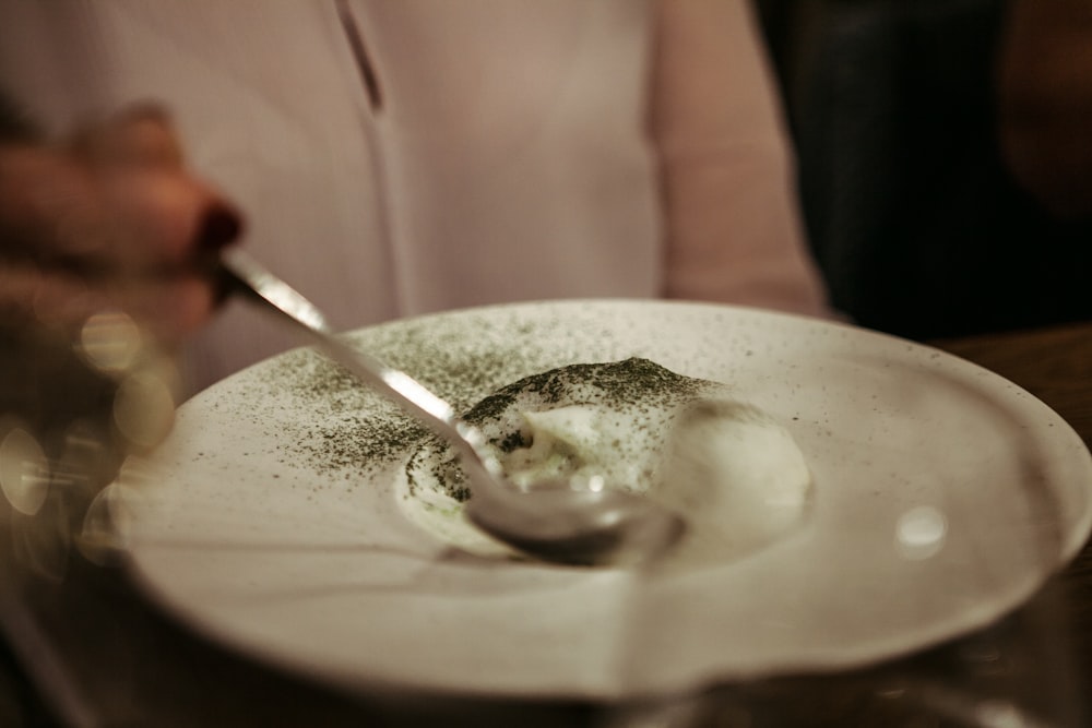 stainless steel spoon on white ceramic plate