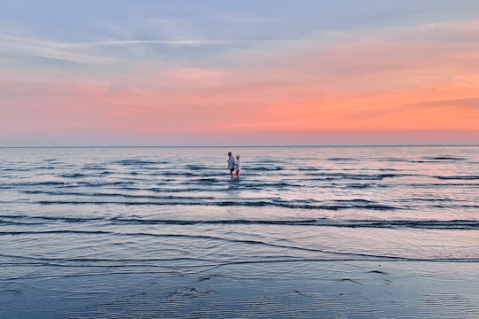 2 person standing on sea shore during sunset in Laguna di Grado Italy