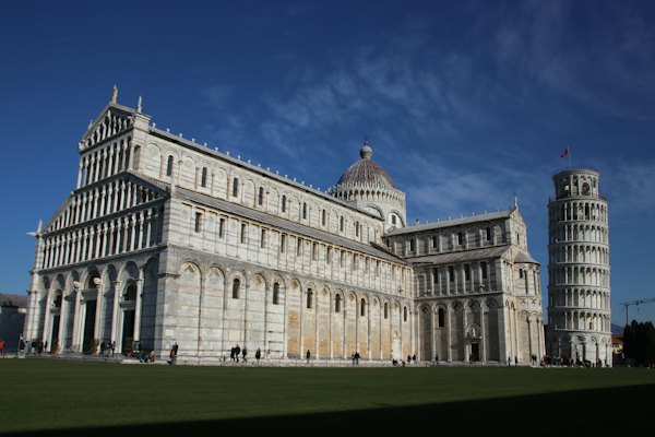 White concrete building under blue sky during daytime — Pisa, Italy