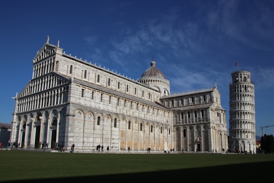 white concrete building under blue sky during daytime in Cattedrale di Pisa Italy