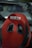 A red Sparco racing seat with black accents is prominently displayed inside a vehicle. The design features a contoured shape, indicating its purpose for high-performance or racing environments. The seat's material appears durable, designed for comfort and support during intense driving conditions.