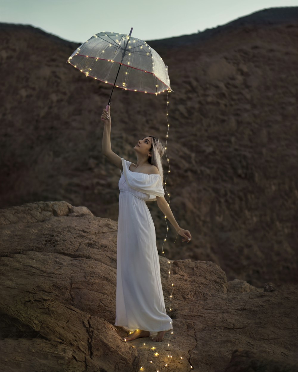 woman in white dress holding umbrella