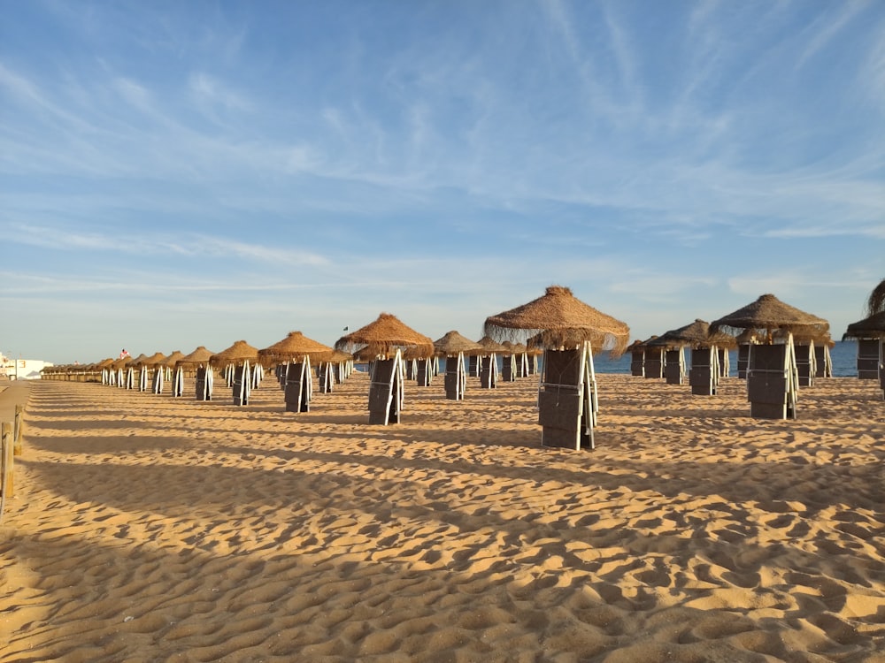 casas de madeira marrom na areia marrom sob o céu azul durante o dia