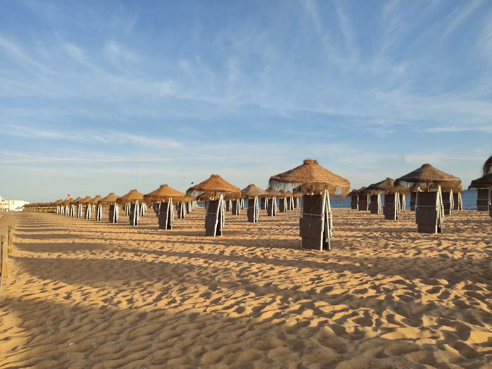 brown wooden houses on brown sand under blue sky during daytime