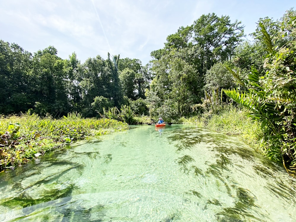 Menschen, die tagsüber mit dem roten Kajak auf dem Fluss fahren