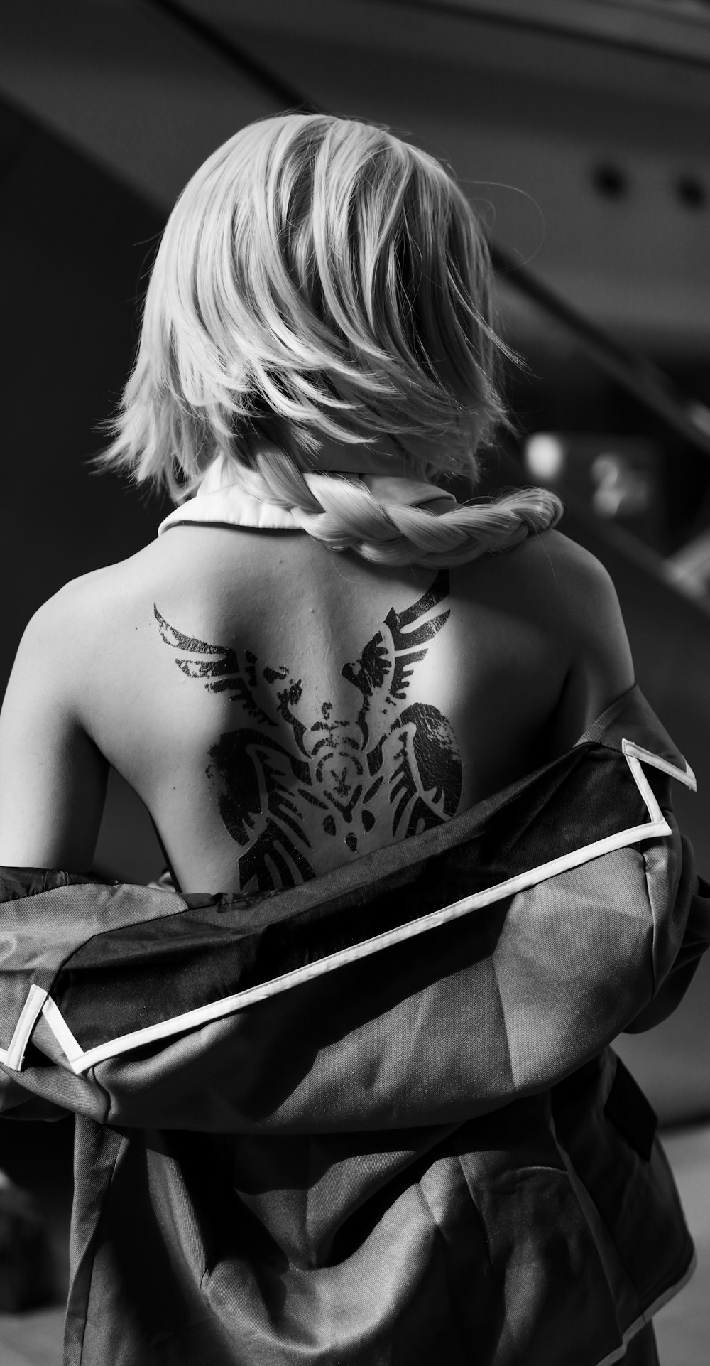 grayscale photo of woman with tattoo on her back