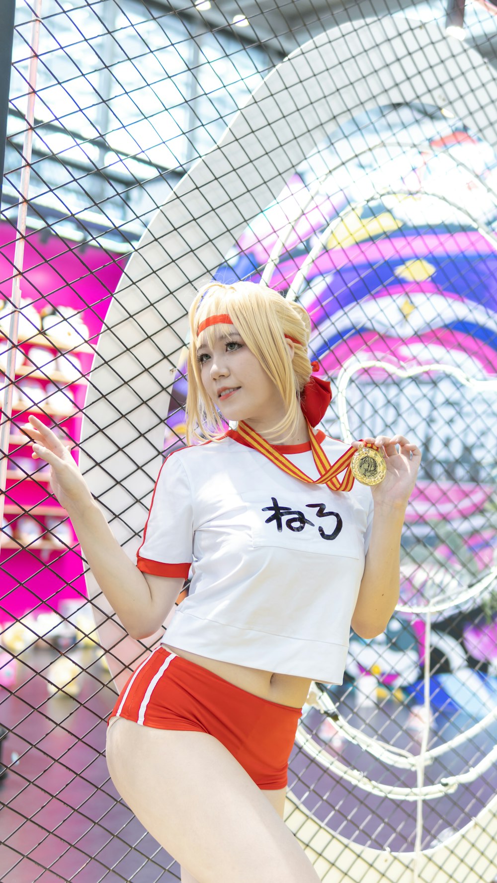 woman in white and red crew neck t-shirt standing beside white metal fence during daytime