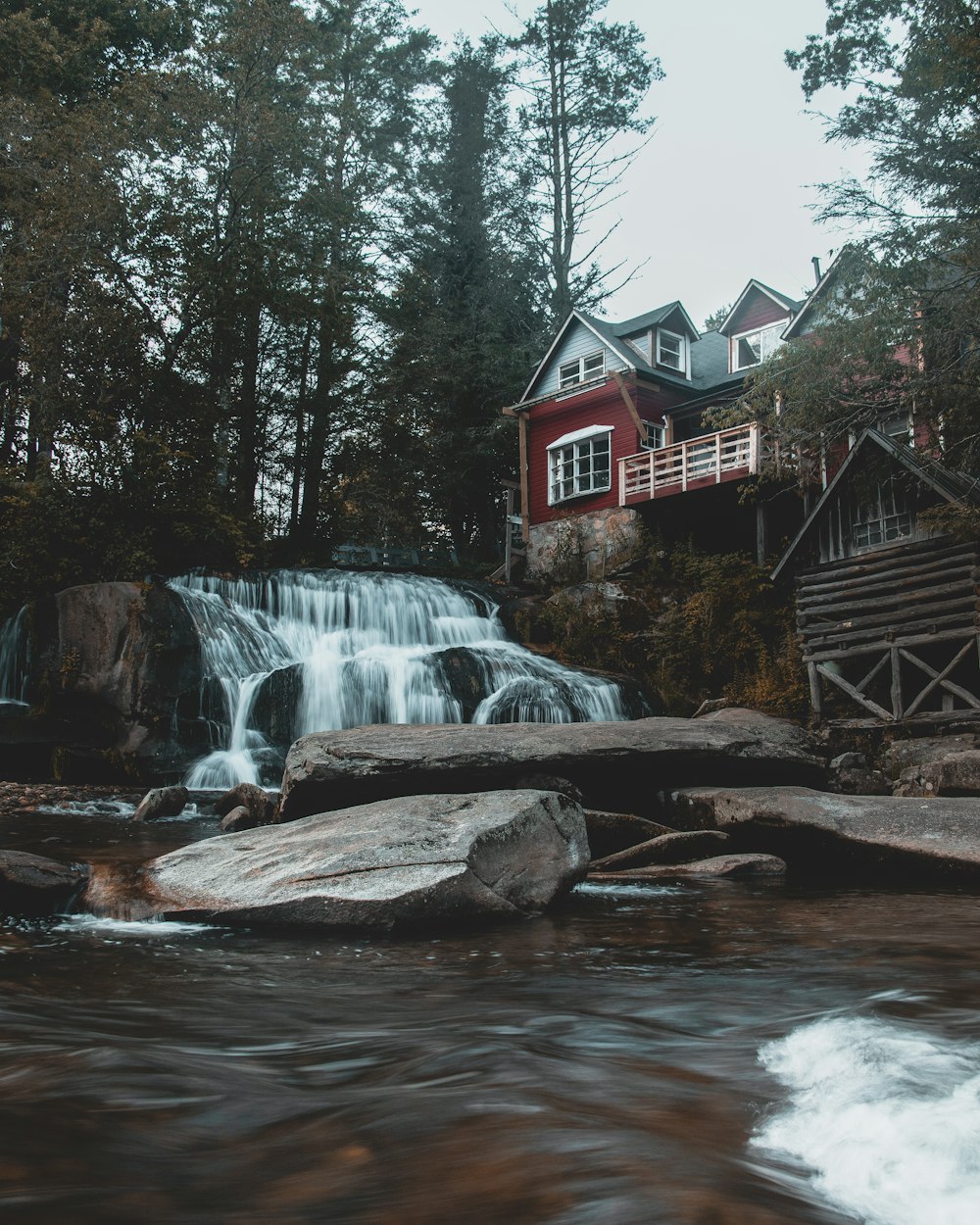 brown wooden house near water falls