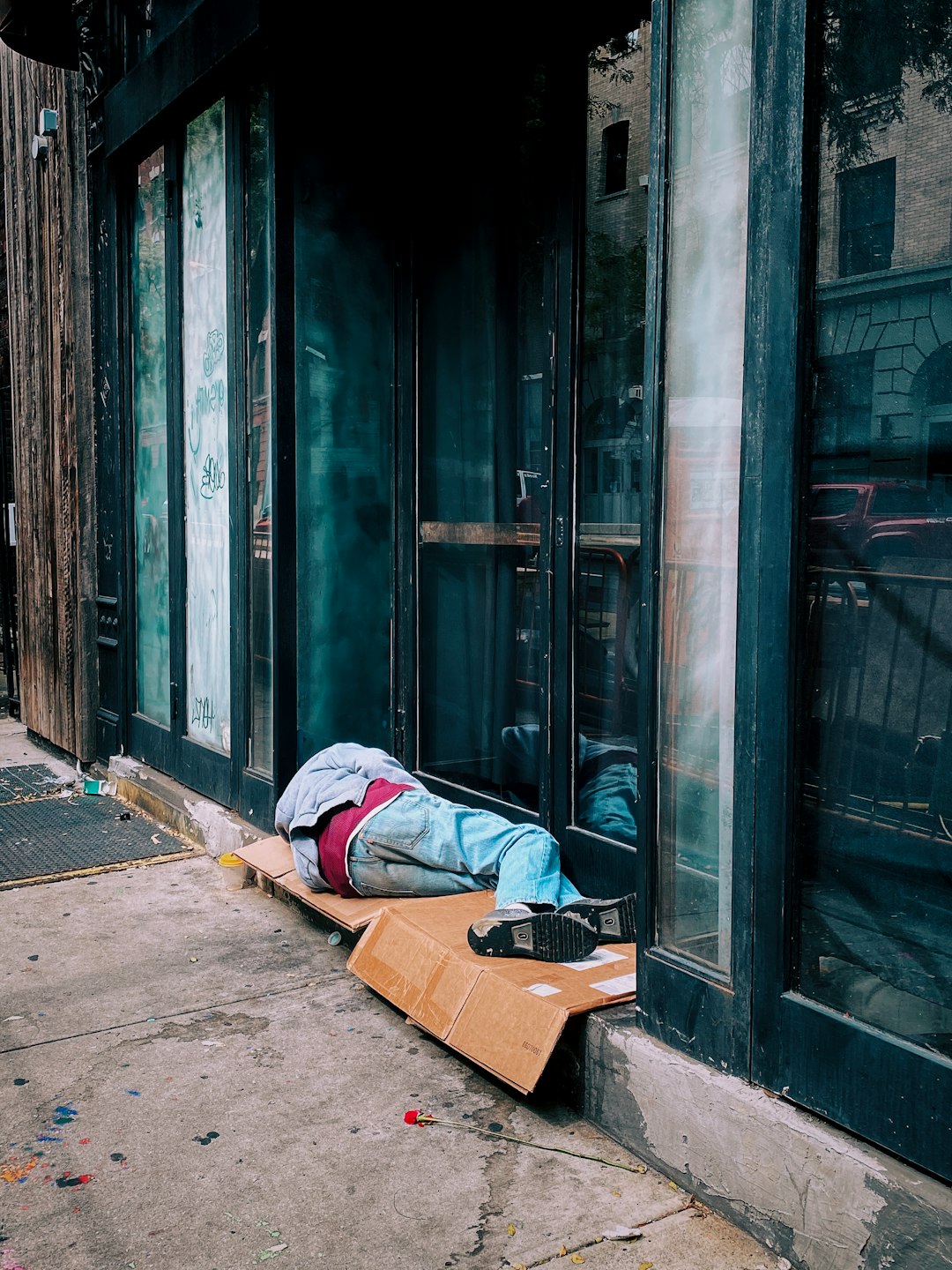 man in blue denim jeans lying on brown cardboard box