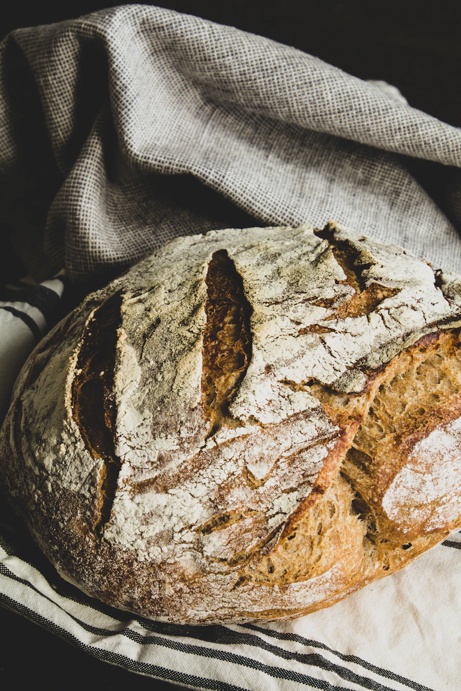 A floured loaf cooling on a linen cloth