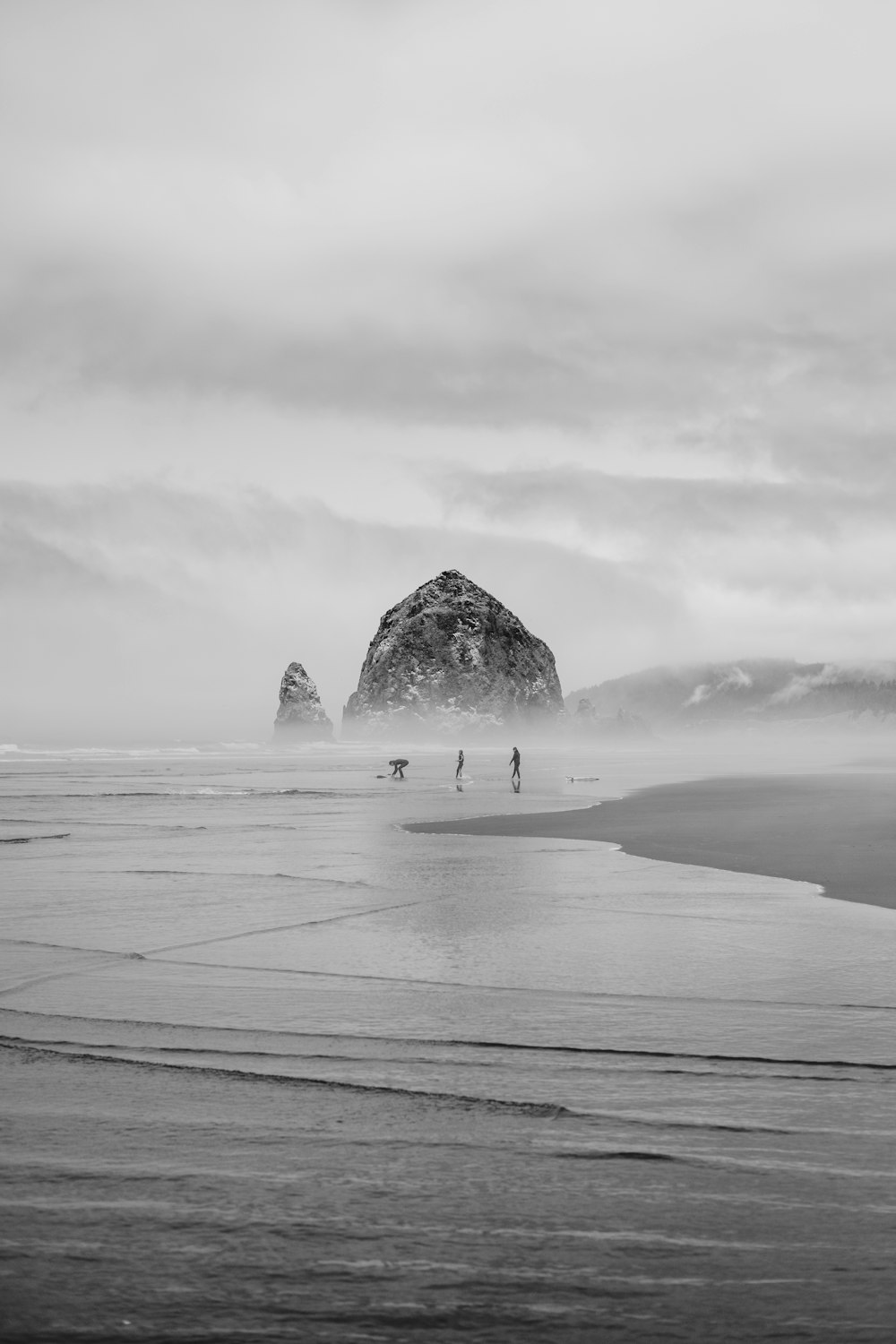 grayscale photo of person walking on beach