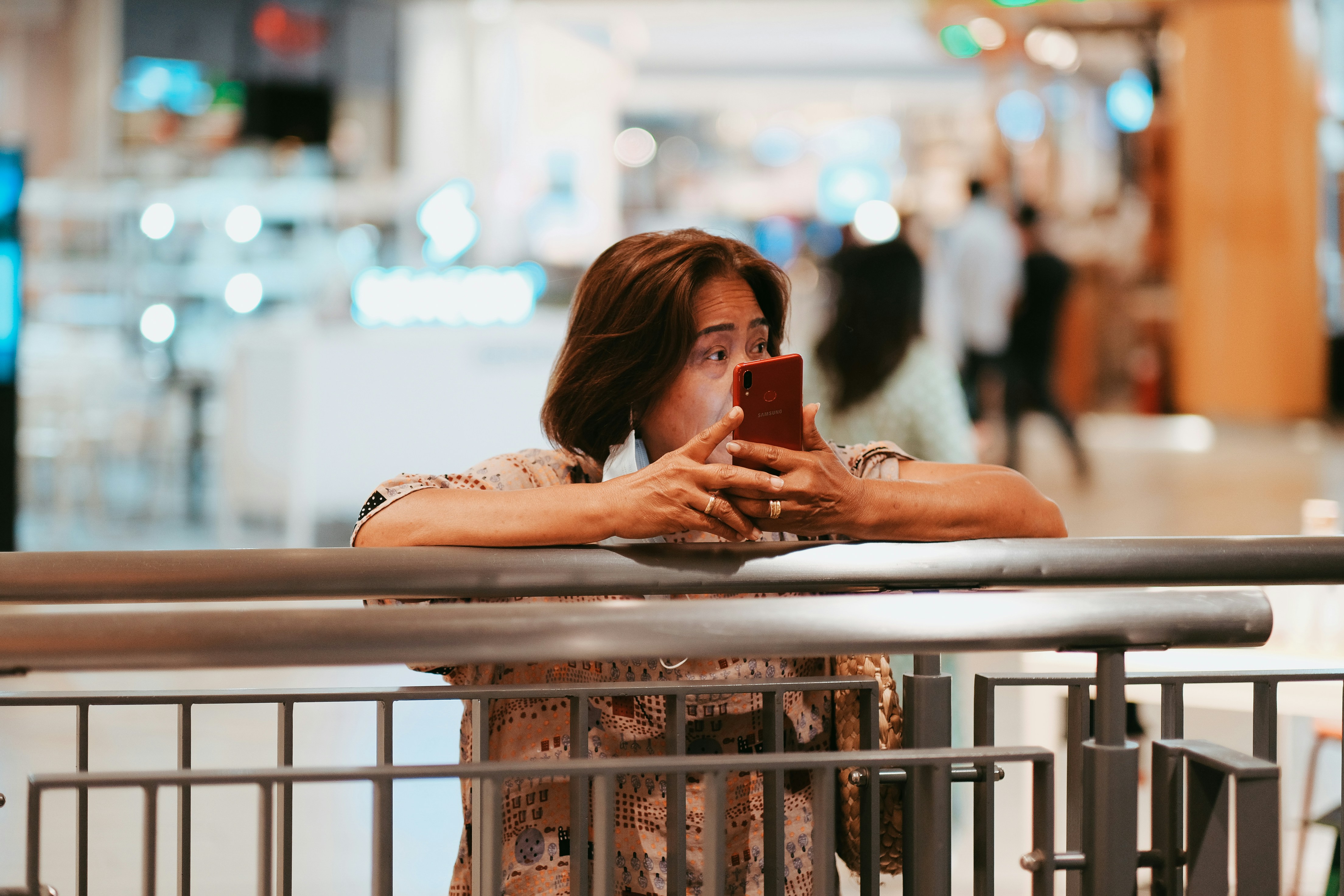 woman in white tank top holding smartphone