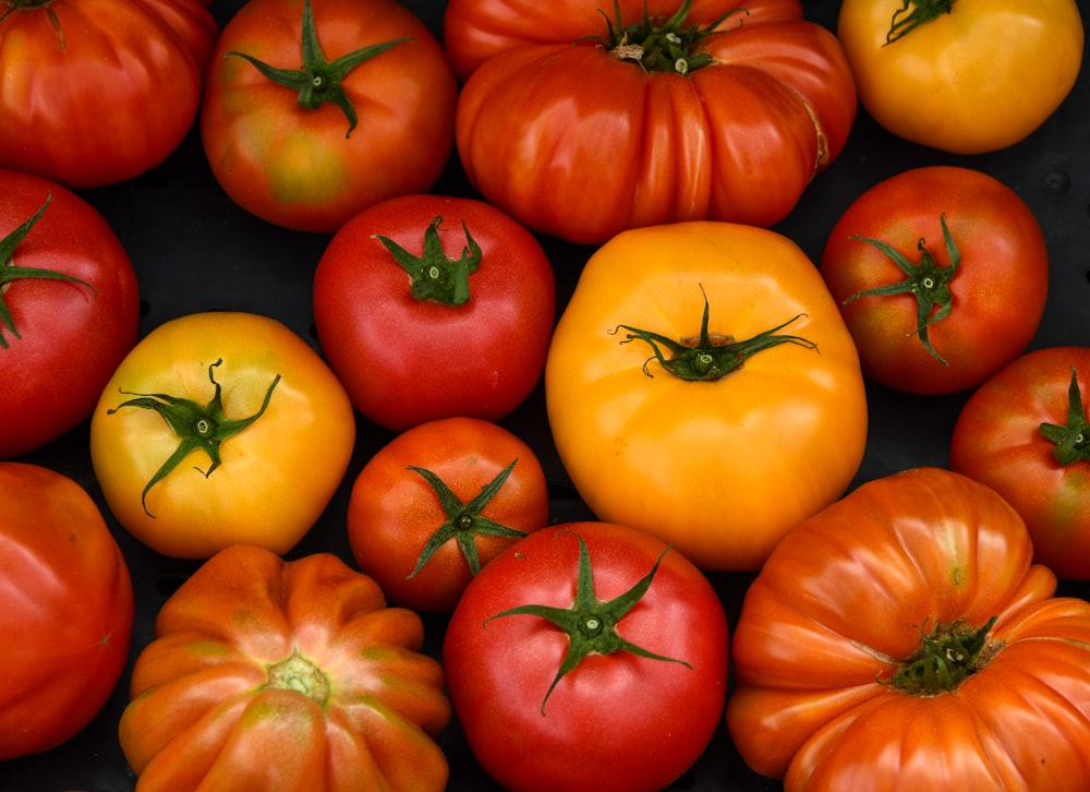 orange tomato fruits on black surface