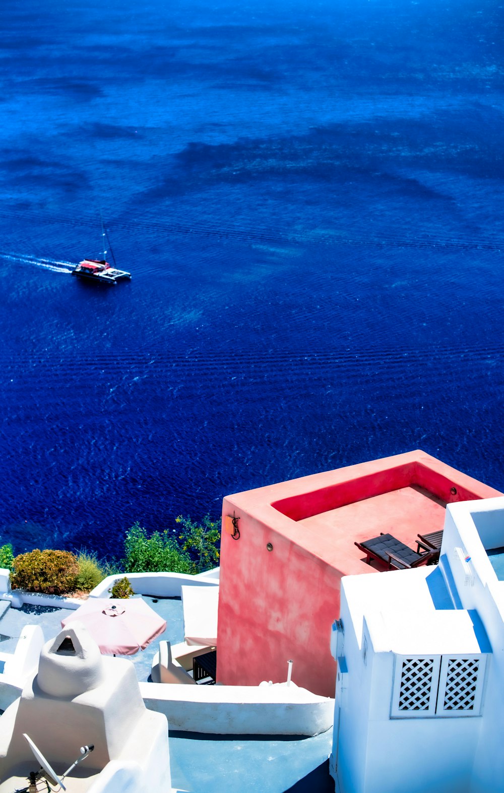 white and red concrete building beside blue sea during daytime