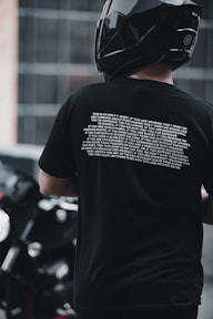 man in black crew neck t-shirt wearing black cap