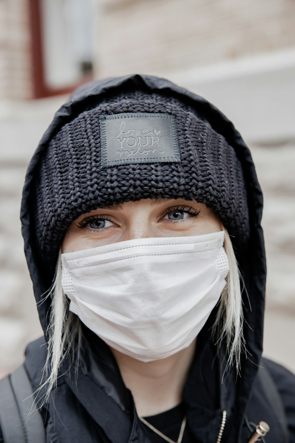 woman in black knit cap and white face mask