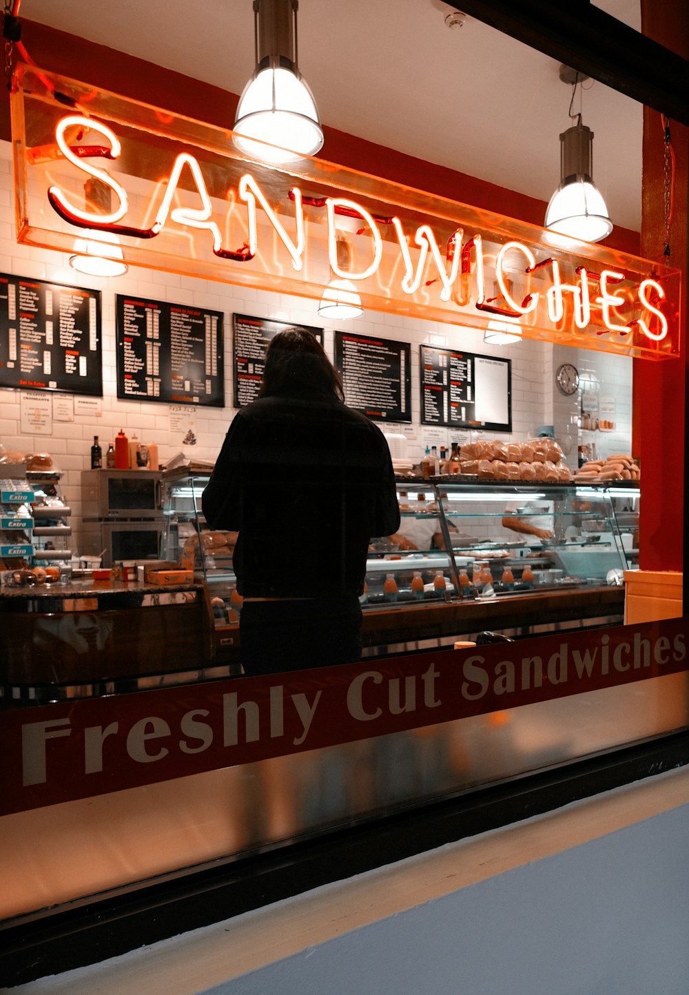 man in black jacket standing in front of brown and white UNKs store